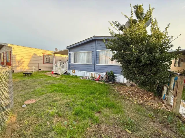 a view of a house with a yard and sitting area