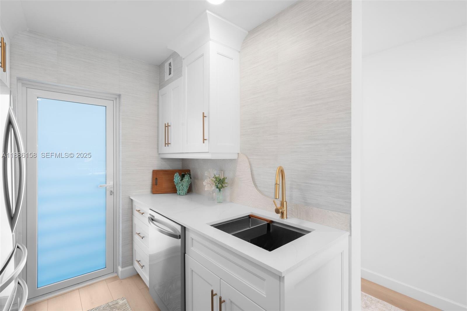 3301 Spanish Trail, Unit 207 Delray Beach, FL 33483 - Photo 12 of 38 a kitchen with white cabinets and a sink