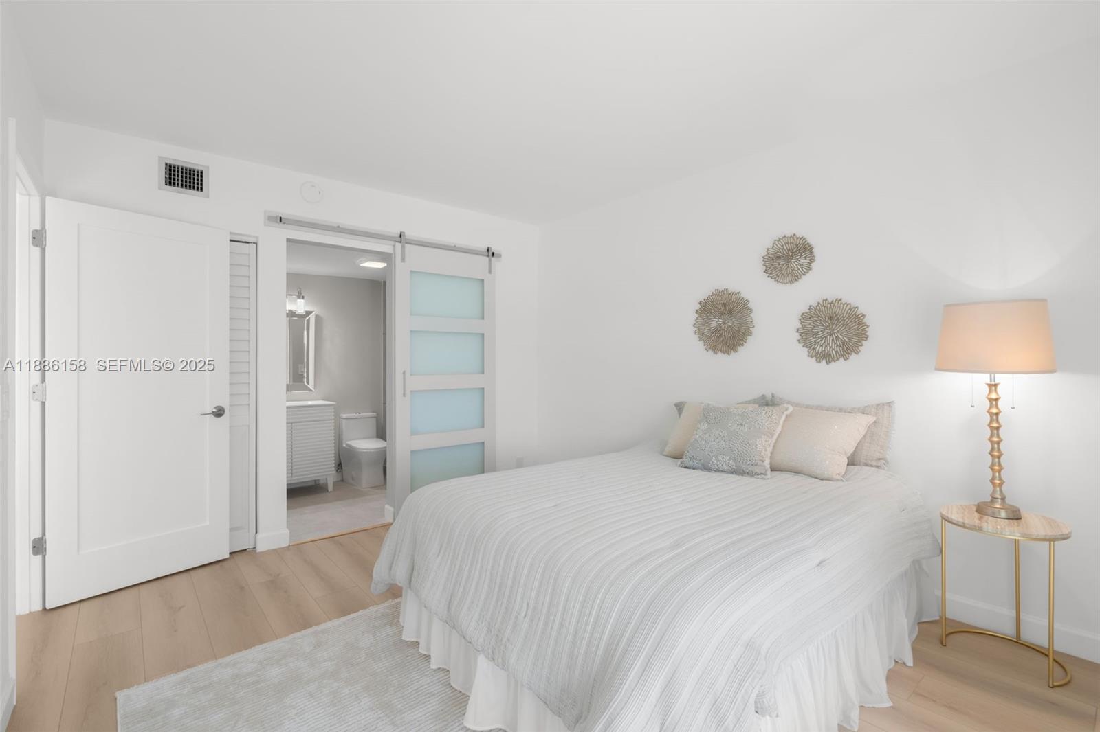 3301 Spanish Trail, Unit 207 Delray Beach, FL 33483 - Photo 19 of 38 a bedroom with a bed and a lamp