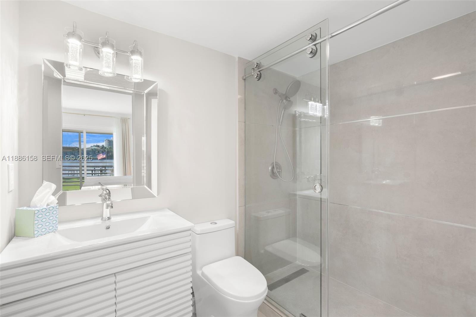 3301 Spanish Trail, Unit 207 Delray Beach, FL 33483 - Photo 20 of 38 a bathroom with a sink toilet a mirror and shower