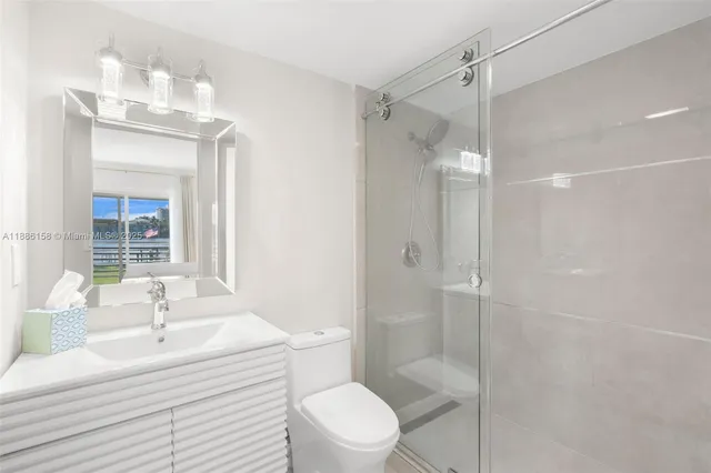 a bathroom with a sink toilet a mirror and shower