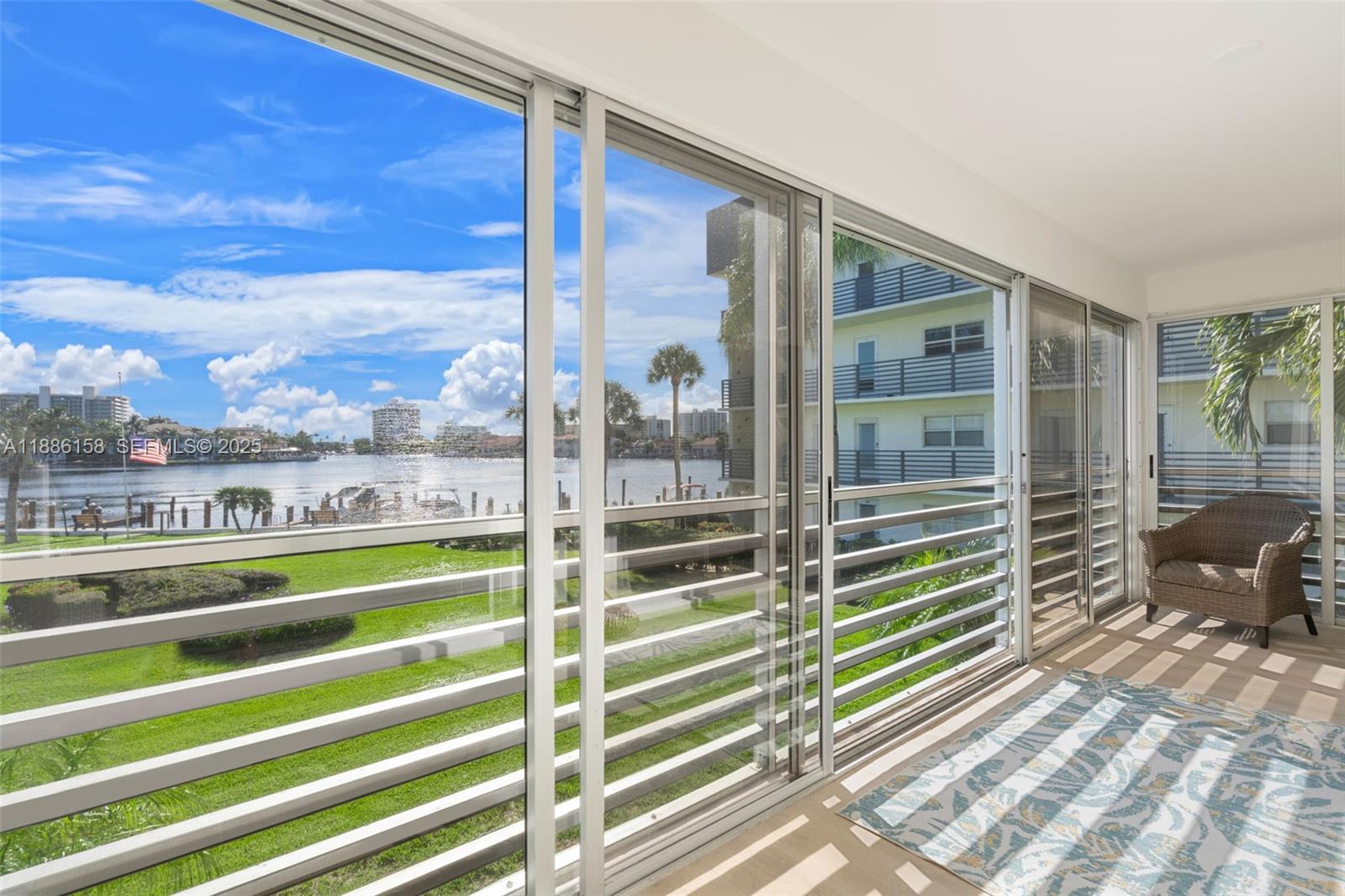 3301 Spanish Trail, Unit 207 Delray Beach, FL 33483 - Photo 22 of 38 a view of a balcony with floor to ceiling windows with wooden floor