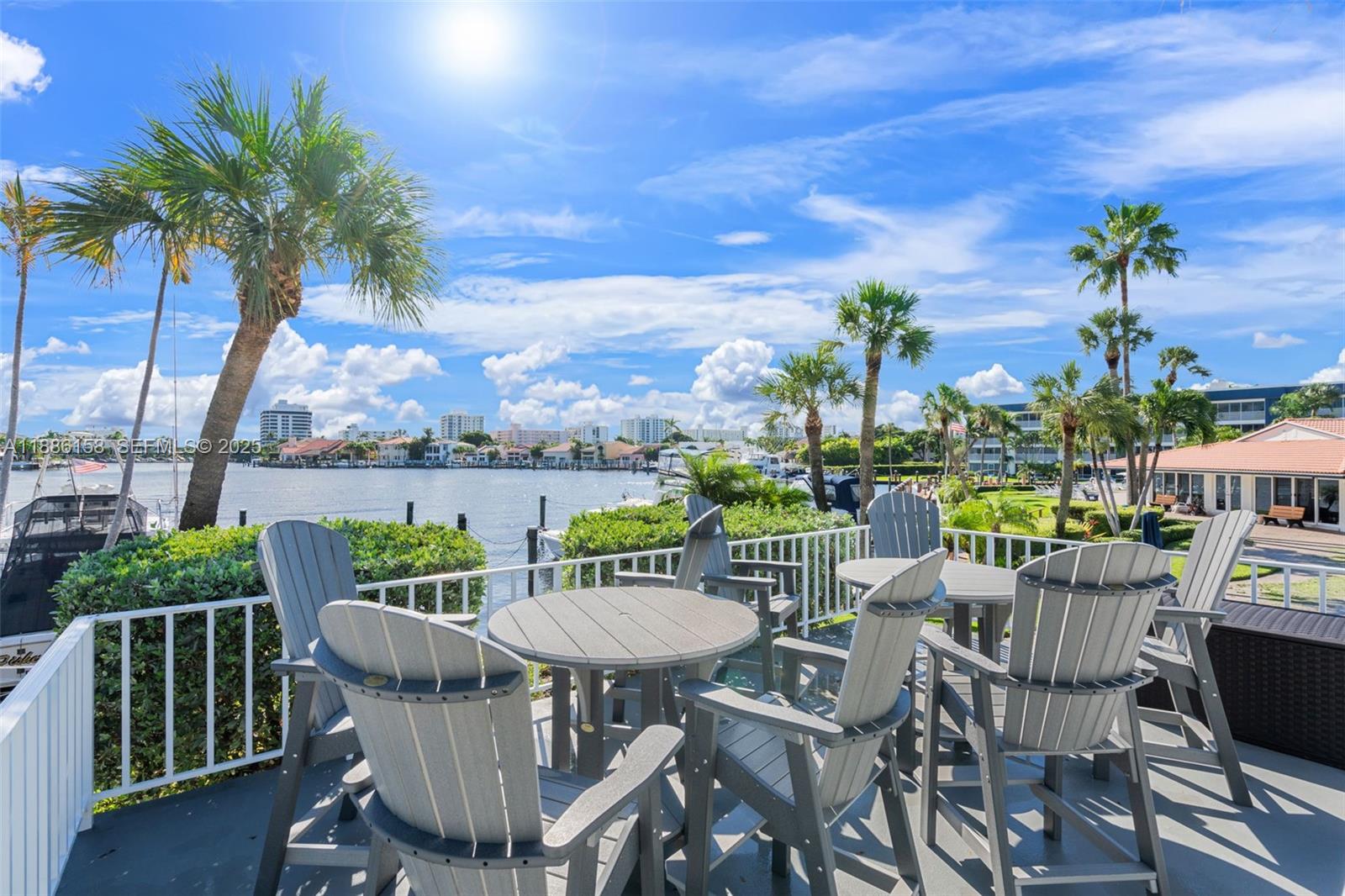 3301 Spanish Trail, Unit 207 Delray Beach, FL 33483 - Photo 24 of 38 a view of a chairs and table in patio with a lake view