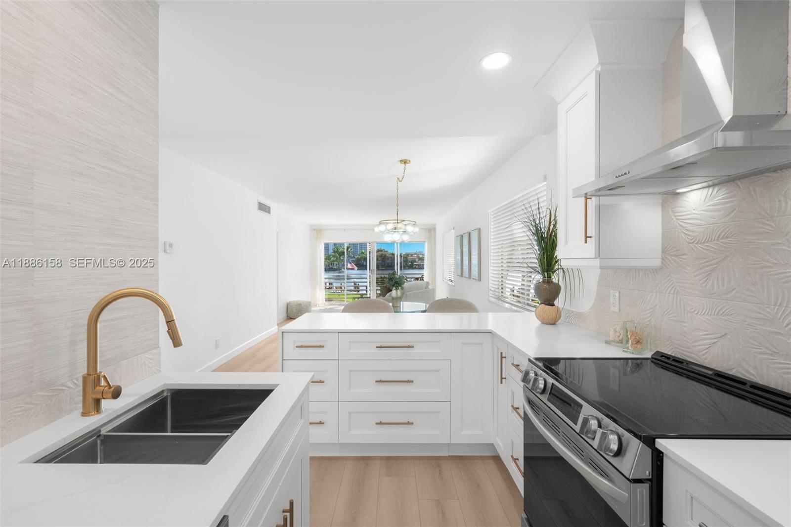 3301 Spanish Trail, Unit 207 Delray Beach, FL 33483 - Photo 5 of 38 a kitchen with a sink and a stove top oven with wooden floor