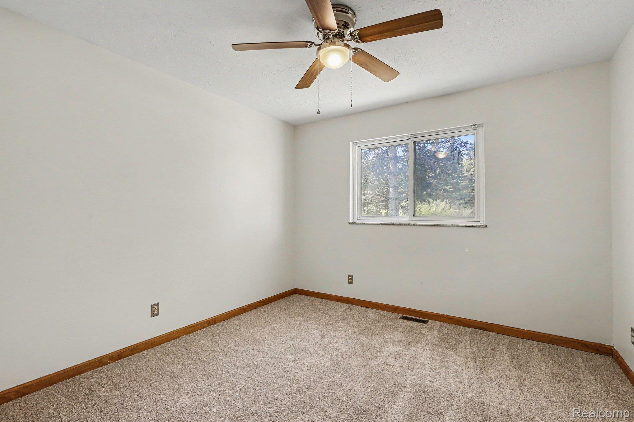 1405 Swarthout Road Pinckney, MI 48169 - Photo 8 of 31 Unfurnished room featuring light carpet and ceiling fan