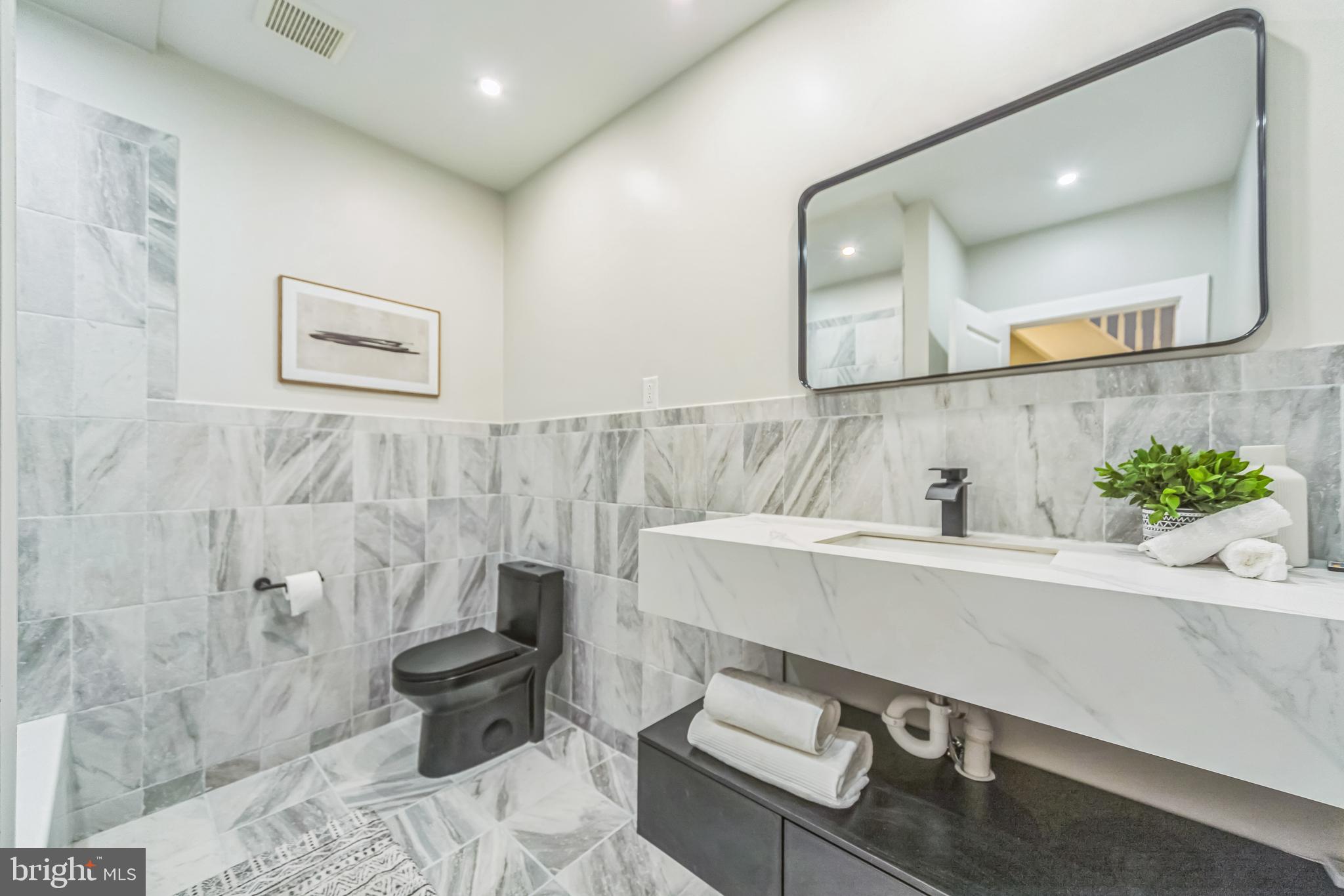 2123 East Norris Street Philadelphia, PA 19125 - Photo 19 of 40 a bathroom with a sink a toilet and a mirror