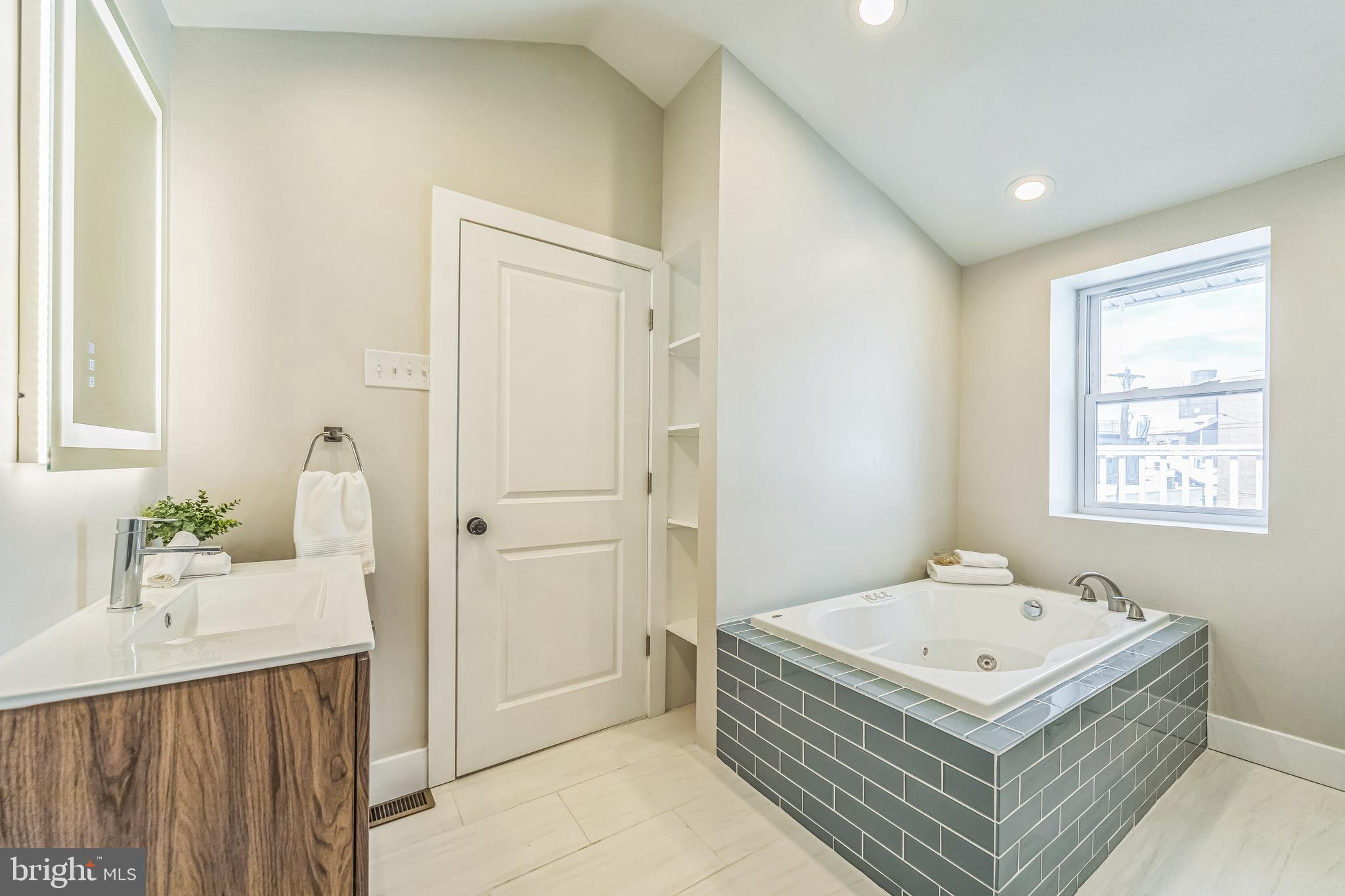 2123 East Norris Street Philadelphia, PA 19125 - Photo 28 of 40 a bathroom with a tub a sink and mirror