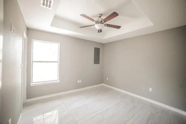 an empty room with a window and a fan