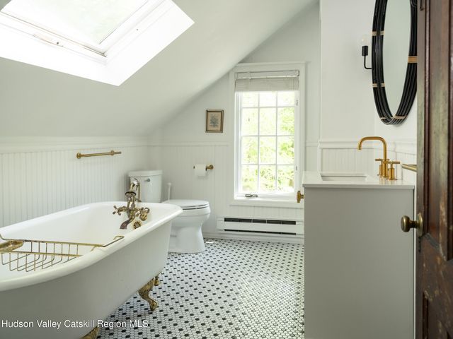 a bathroom with a bathtub a sink a window and a shower