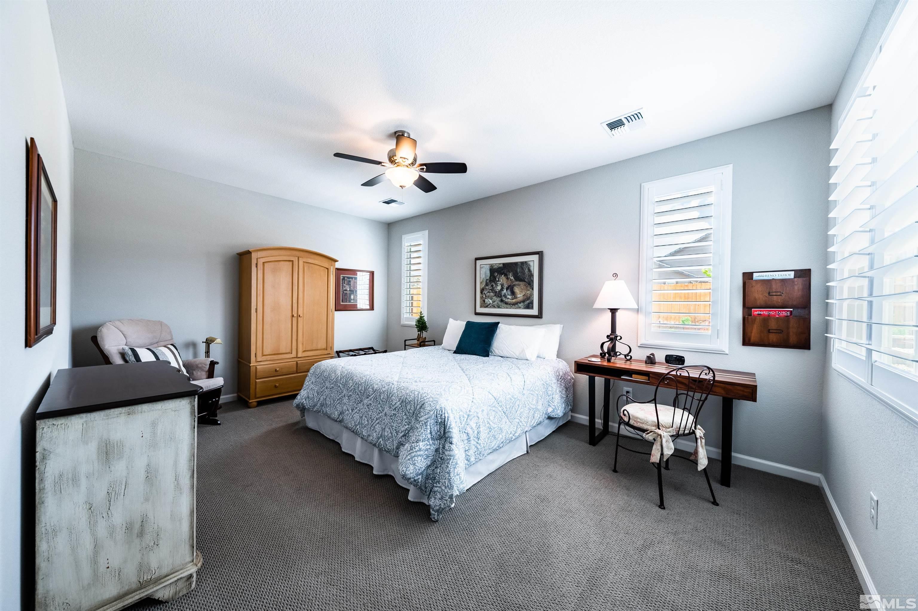 9860 Nahar Lane Reno, NV 89521 - Photo 17 of 40 a bedroom with a bed and a chandelier