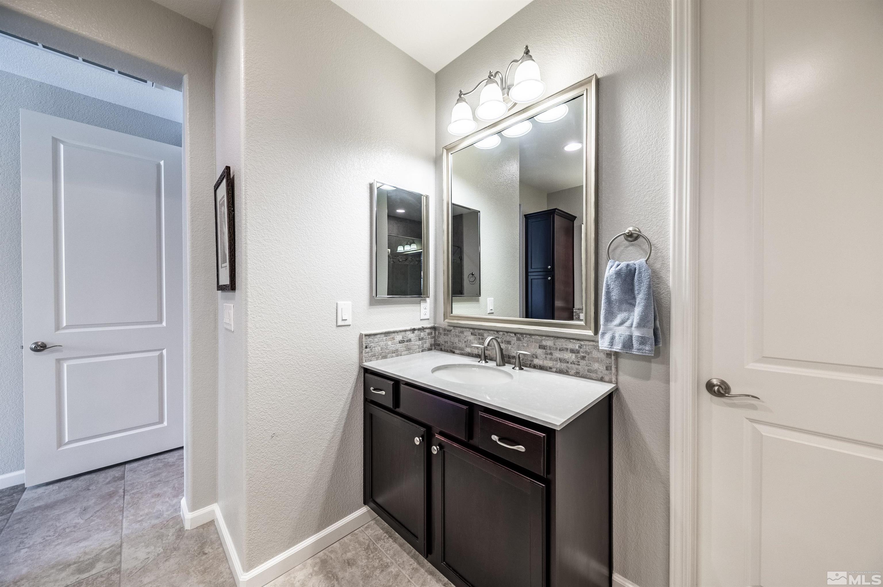 9860 Nahar Lane Reno, NV 89521 - Photo 19 of 40 a bathroom with a sink vanity and a mirror