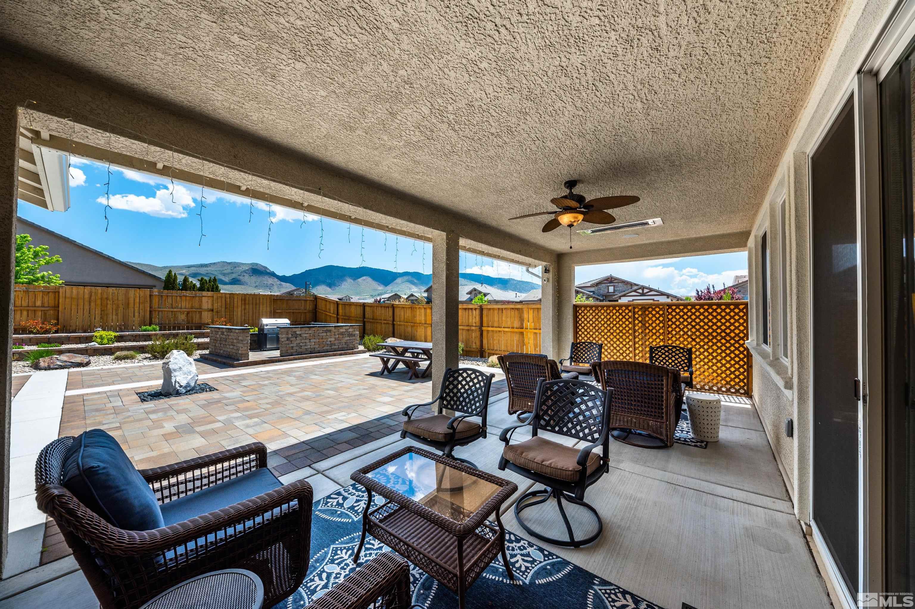 9860 Nahar Lane Reno, NV 89521 - Photo 23 of 40 a living room with furniture a floor to ceiling window and a flat screen tv