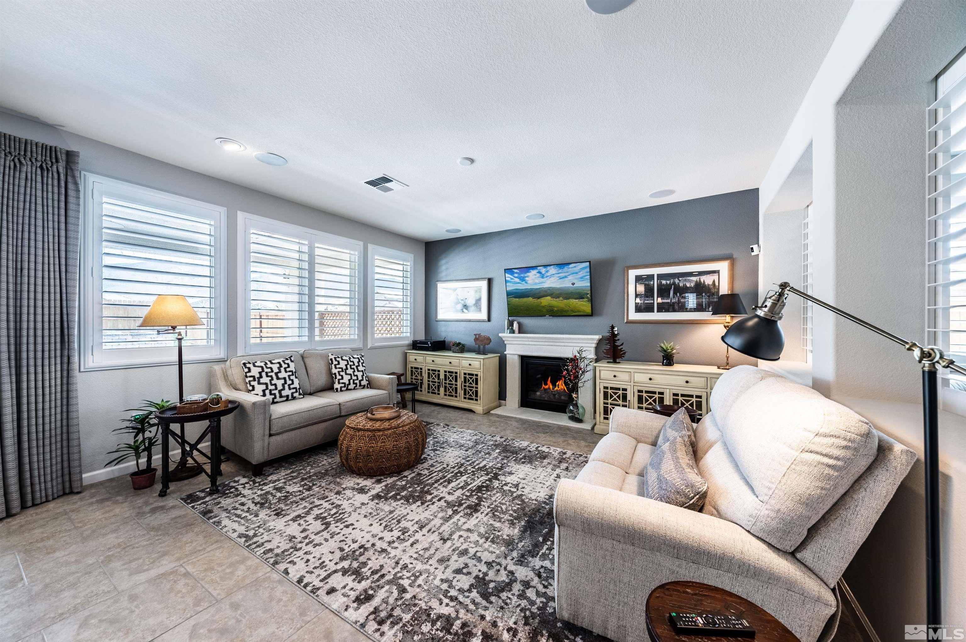 9860 Nahar Lane Reno, NV 89521 - Photo 7 of 40 a living room with furniture a fireplace and a large window