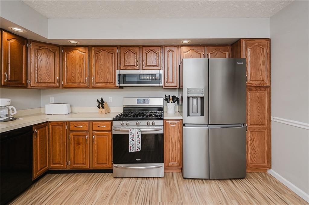 979 Barclay Road Indiana, PA 15701 - Photo 11 of 32 a kitchen with stainless steel appliances granite countertop a refrigerator stove a sink and dishwasher with wooden floor