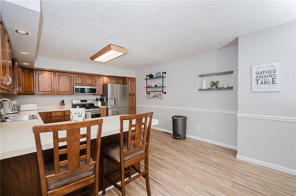 979 Barclay Road Indiana, PA 15701 - Photo 9 of 32 a kitchen with stainless steel appliances granite countertop a dining table chairs refrigerator and sink