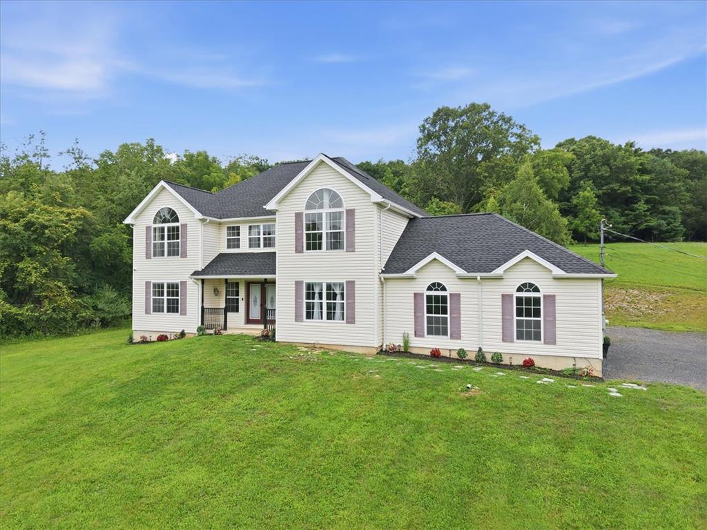 387 Blue Ridge Road Saylorsburg, PA 18353 - Photo 2 of 90 A classic two-story residence with a charming facade is set on a lush, green hillside.