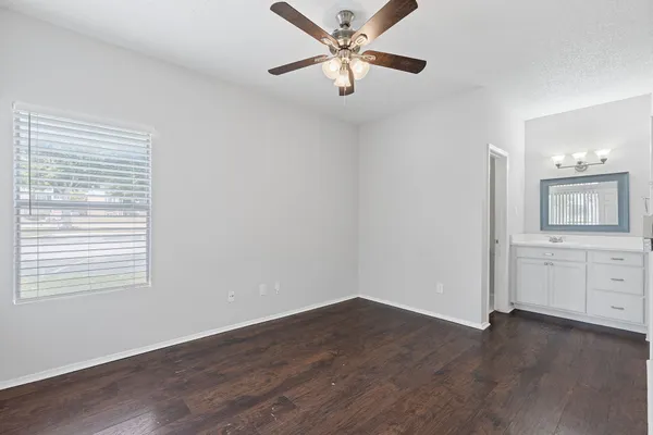 a view of a livingroom with wooden floor and a ceiling fan