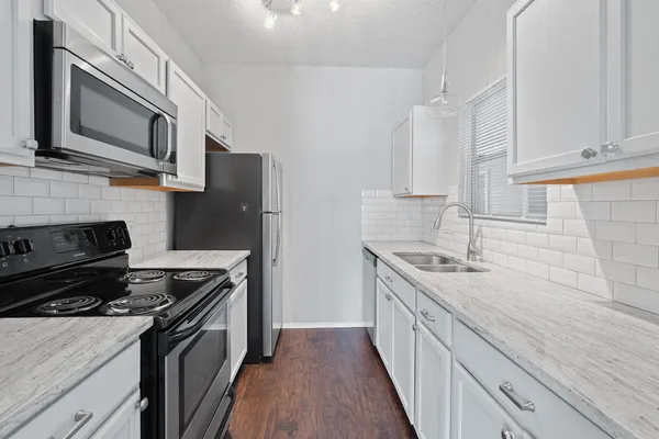 a kitchen with stainless steel appliances granite countertop a stove microwave sink and refrigerator