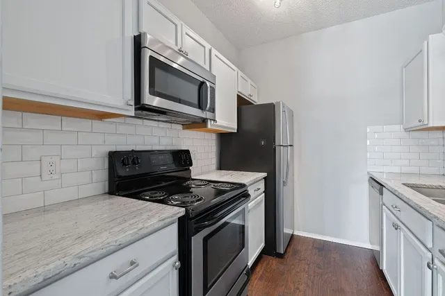 a kitchen with stainless steel appliances granite countertop a stove microwave sink and refrigerator