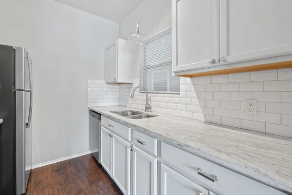 a kitchen with stainless steel appliances granite countertop a sink and dishwasher a stove with wooden floor