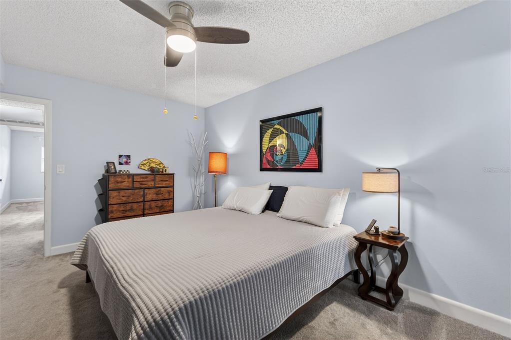 3740 58th Street North, Unit 110 St. Petersburg, FL 33710 - Photo 15 of 27 a bedroom with a bed and a chandelier