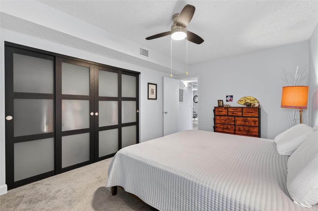 3740 58th Street North, Unit 110 St. Petersburg, FL 33710 - Photo 16 of 27 a bedroom with a large bed and a chandelier fan