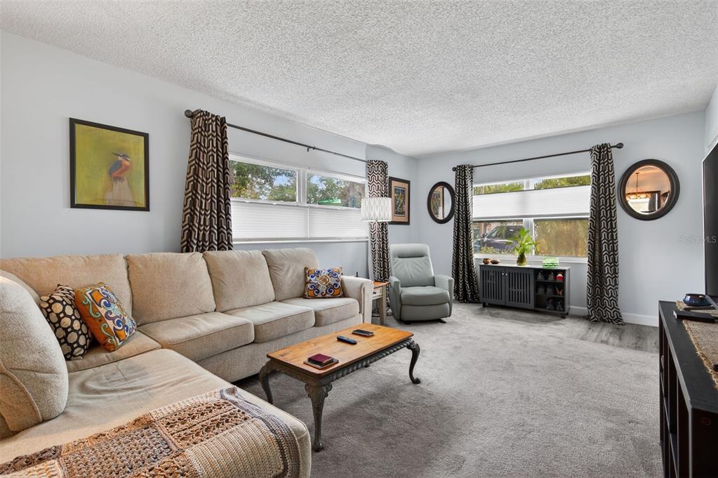 3740 58th Street North, Unit 110 St. Petersburg, FL 33710 - Photo 2 of 27 a living room with furniture and a large window