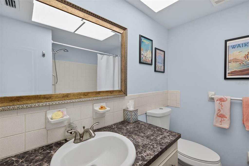3740 58th Street North, Unit 110 St. Petersburg, FL 33710 - Photo 21 of 27 a bathroom with a granite countertop toilet sink and mirror