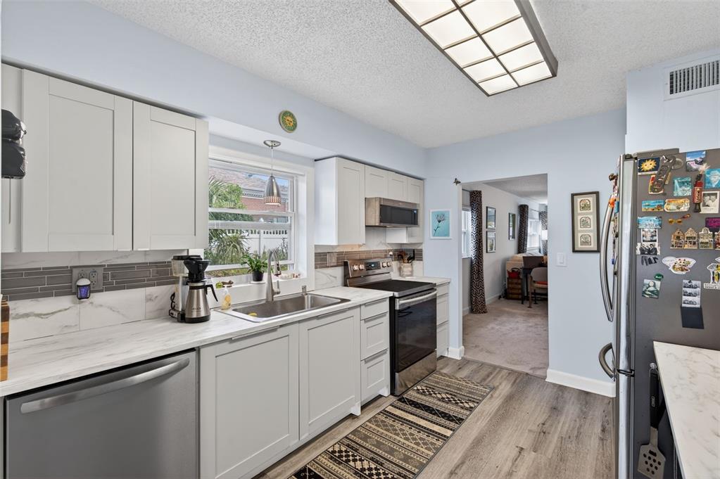 3740 58th Street North, Unit 110 St. Petersburg, FL 33710 - Photo 4 of 27 a kitchen with a sink stove and refrigerator