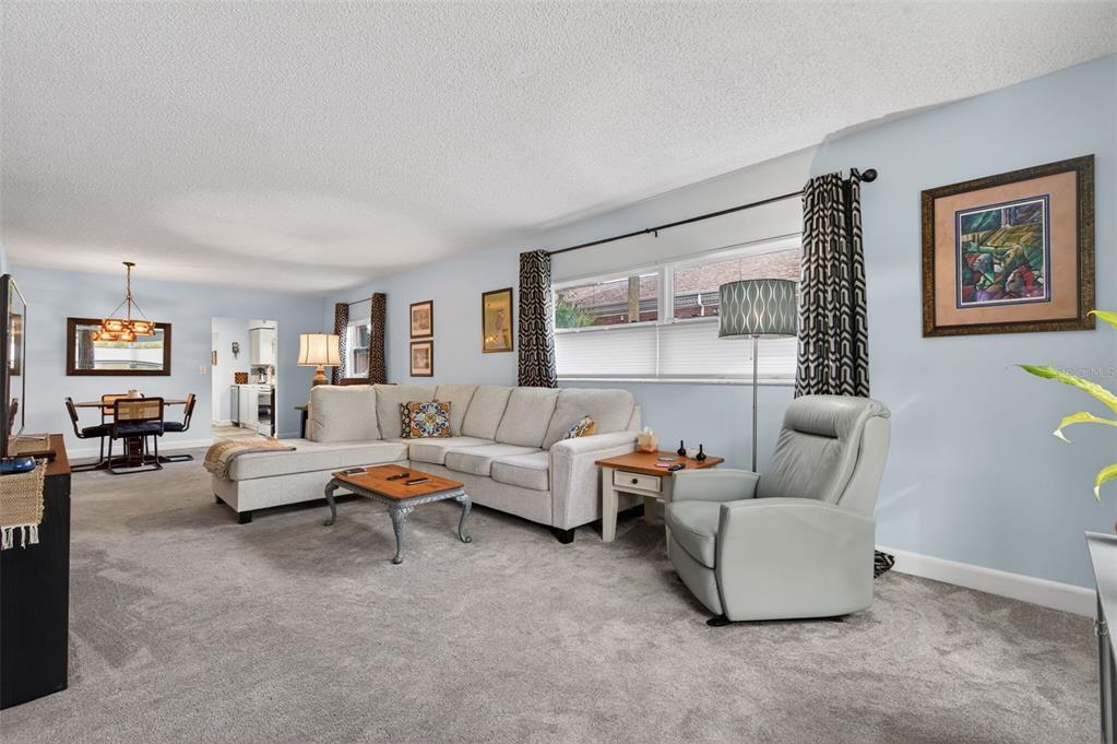3740 58th Street North, Unit 110 St. Petersburg, FL 33710 - Photo 9 of 27 a living room with furniture and a large window