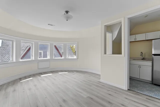 a view of empty room with a window and wooden floor