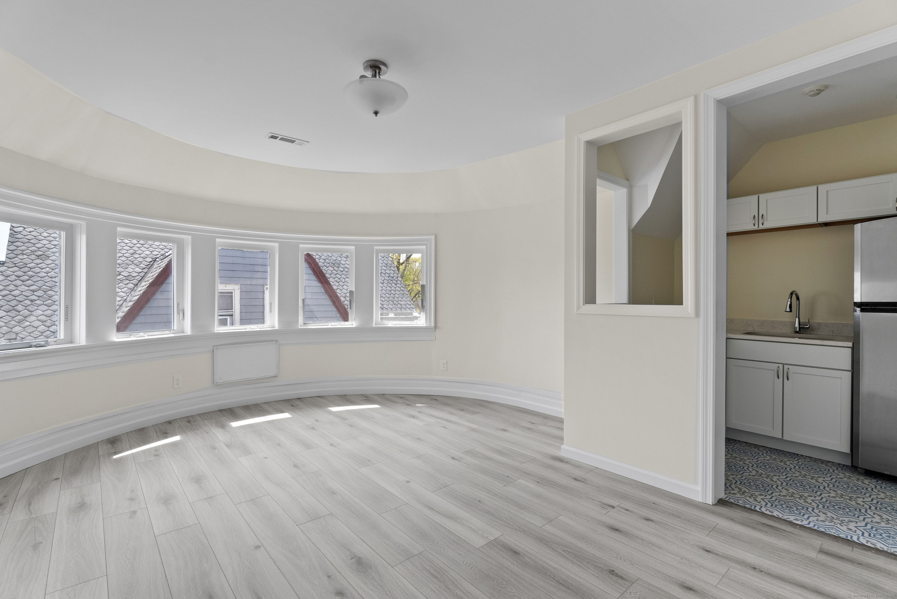 a view of empty room with a window and wooden floor