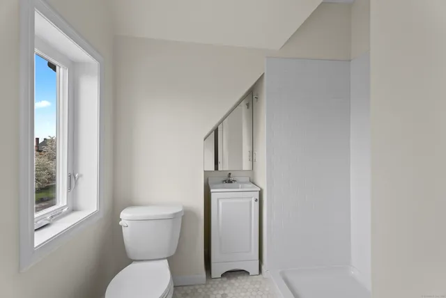 a bathroom with a toilet a sink and window