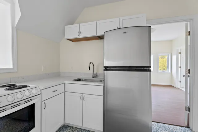 a kitchen with a refrigerator sink stove and cabinets