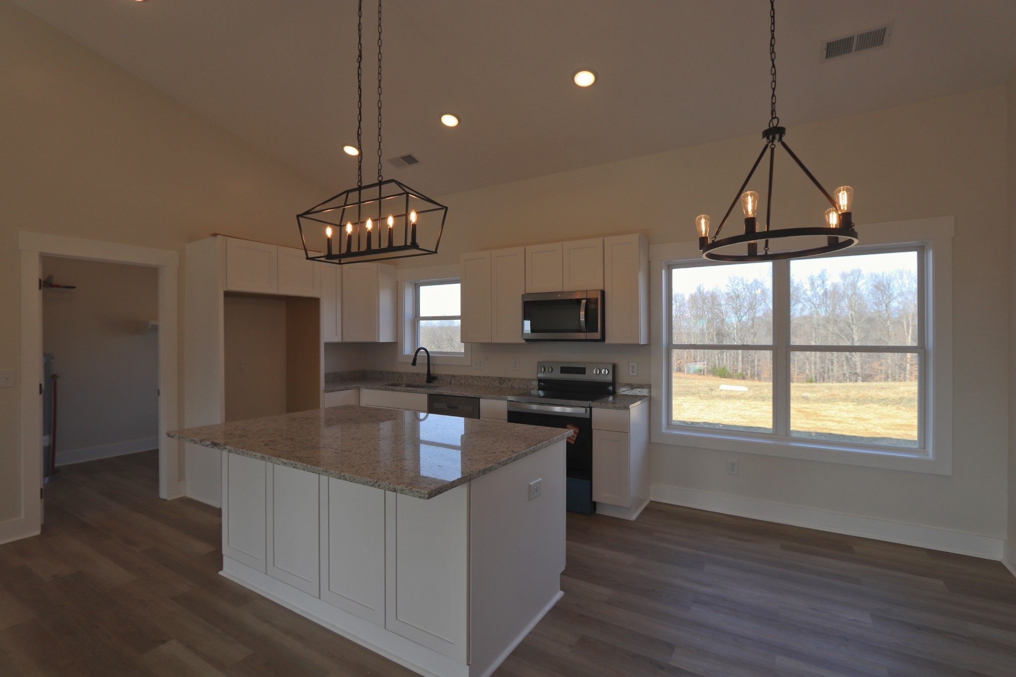 2679 Dotson Road Lafayette, TN 37083 - Photo 7 of 25 a kitchen with granite countertop a stove a sink a refrigerator dining table and chairs
