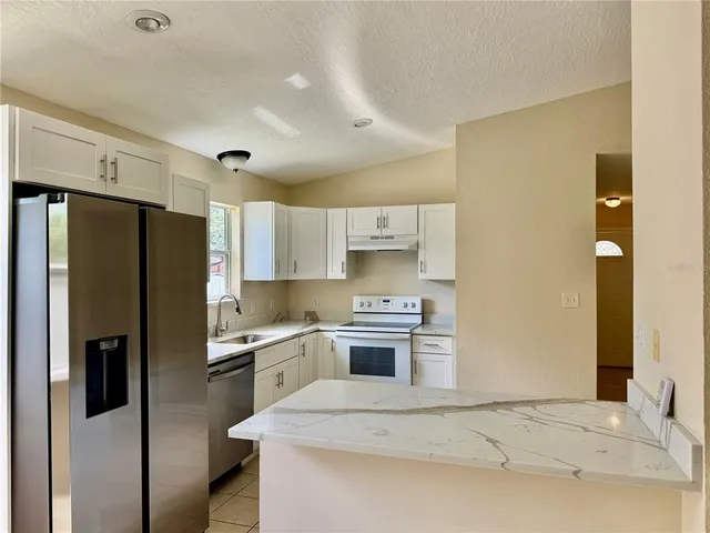 a kitchen with stainless steel appliances a refrigerator sink and stove