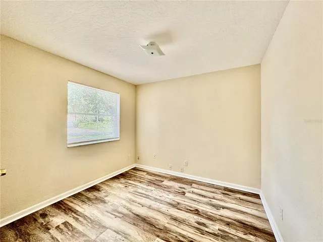 a view of a room with wooden floor and white walls