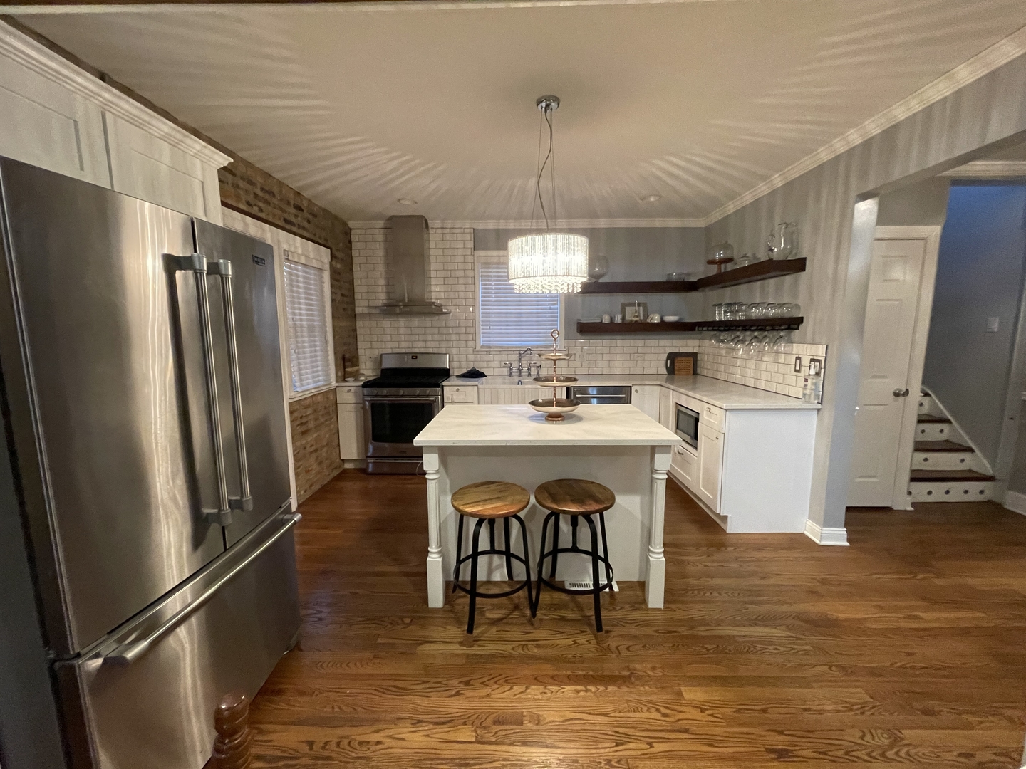 10441 South Prairie Avenue Chicago, IL 60628 - Photo 6 of 36 a kitchen with stainless steel appliances a refrigerator a stove a sink dishwasher a dining table and chairs with wooden floor
