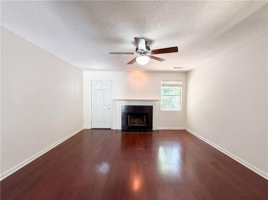 3753 Soapstone Road Decatur, GA 30034 - Photo 3 of 26 a view of an empty room with wooden floor fireplace and a window