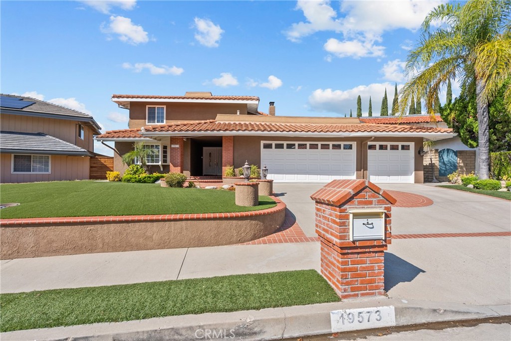 a front view of a building with a garden and plants