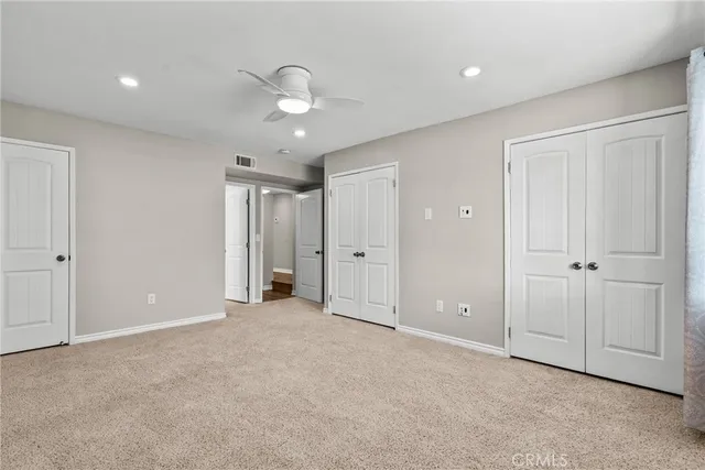 an empty room with closet and windows