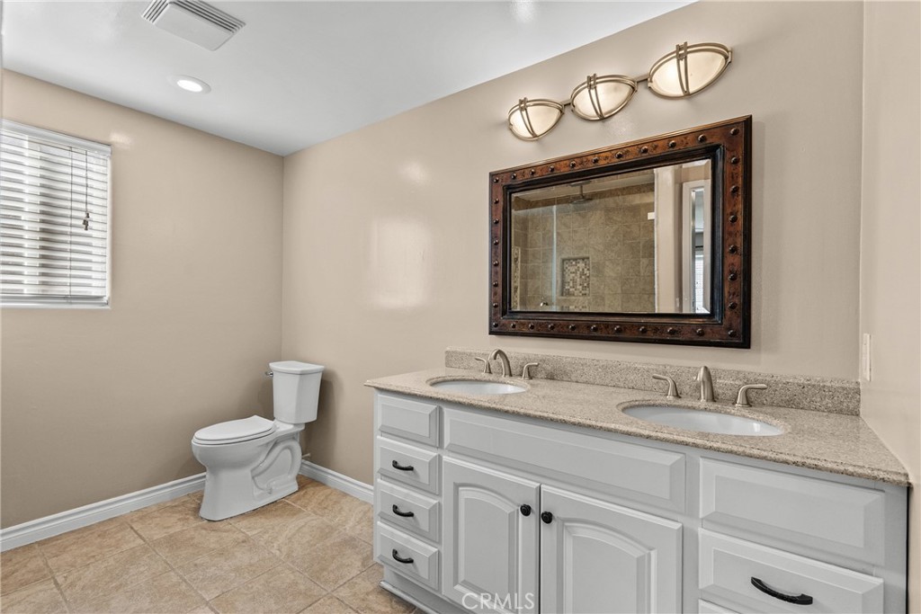 19573 Pine Valley Avenue Porter Ranch, CA 91326 - Photo 12 of 48 a bathroom with a toilet sink and mirror