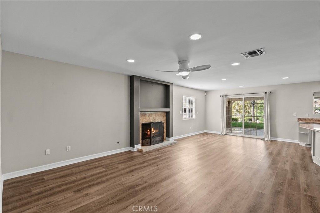 19573 Pine Valley Avenue Porter Ranch, CA 91326 - Photo 15 of 48 an empty room with wooden floor fireplace and windows