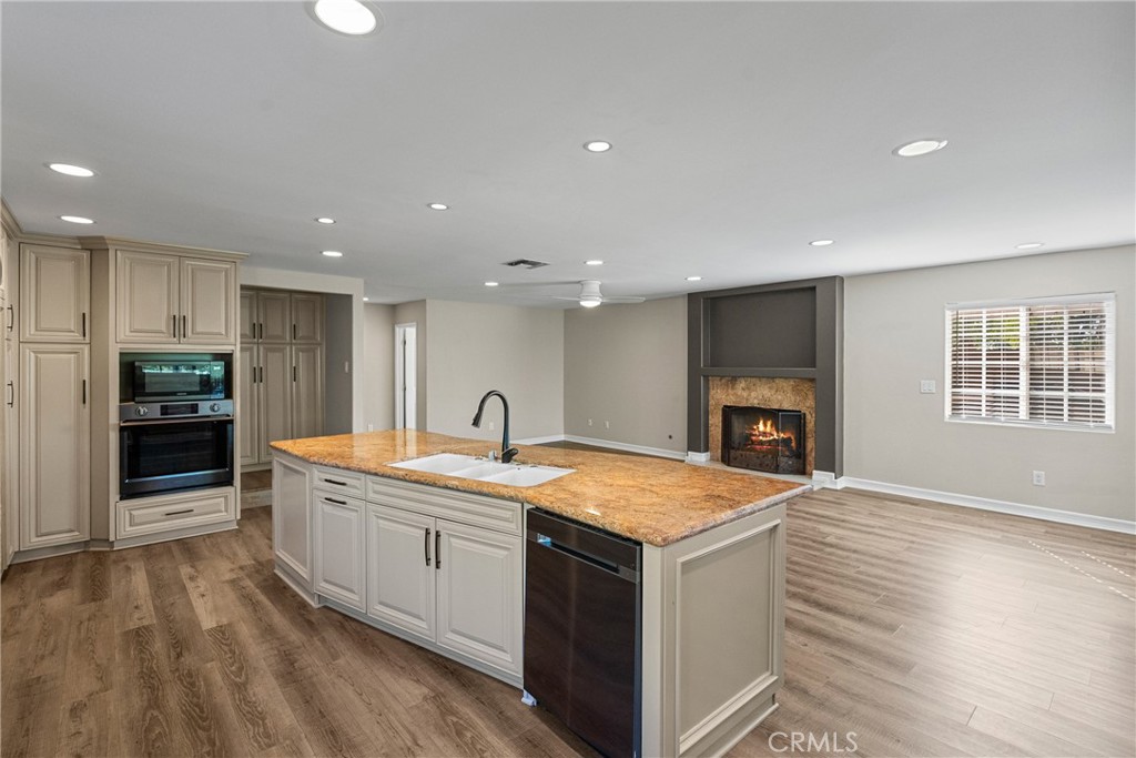 19573 Pine Valley Avenue Porter Ranch, CA 91326 - Photo 20 of 48 a large kitchen with a sink and dishwasher a stove with wooden floors