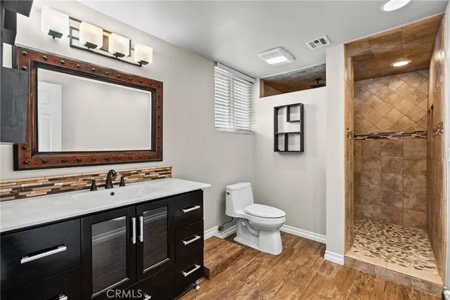 a bathroom with a toilet sink double vanity and mirror