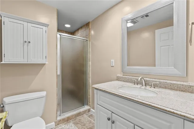 a bathroom with a granite countertop sink toilet and shower