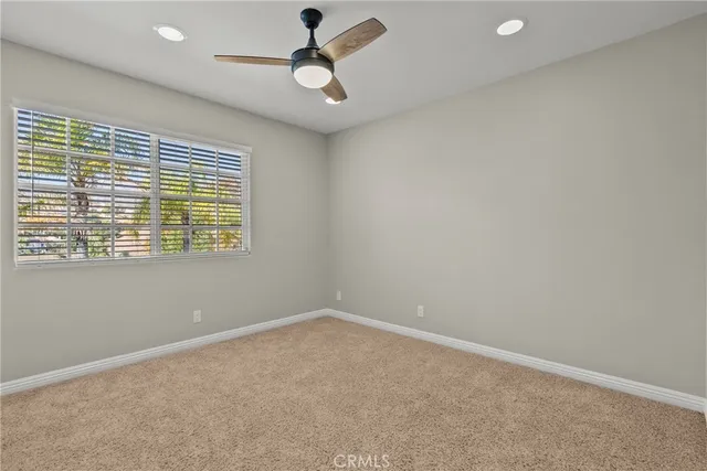 an empty room with a window and a fan