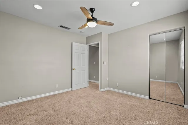 an empty room with closet and windows