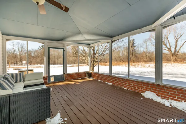 a view of an empty room with wooden floor and a floor to ceiling window