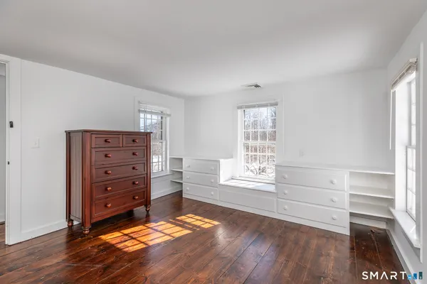 a view of an empty room with wooden floor and a floor to ceiling window